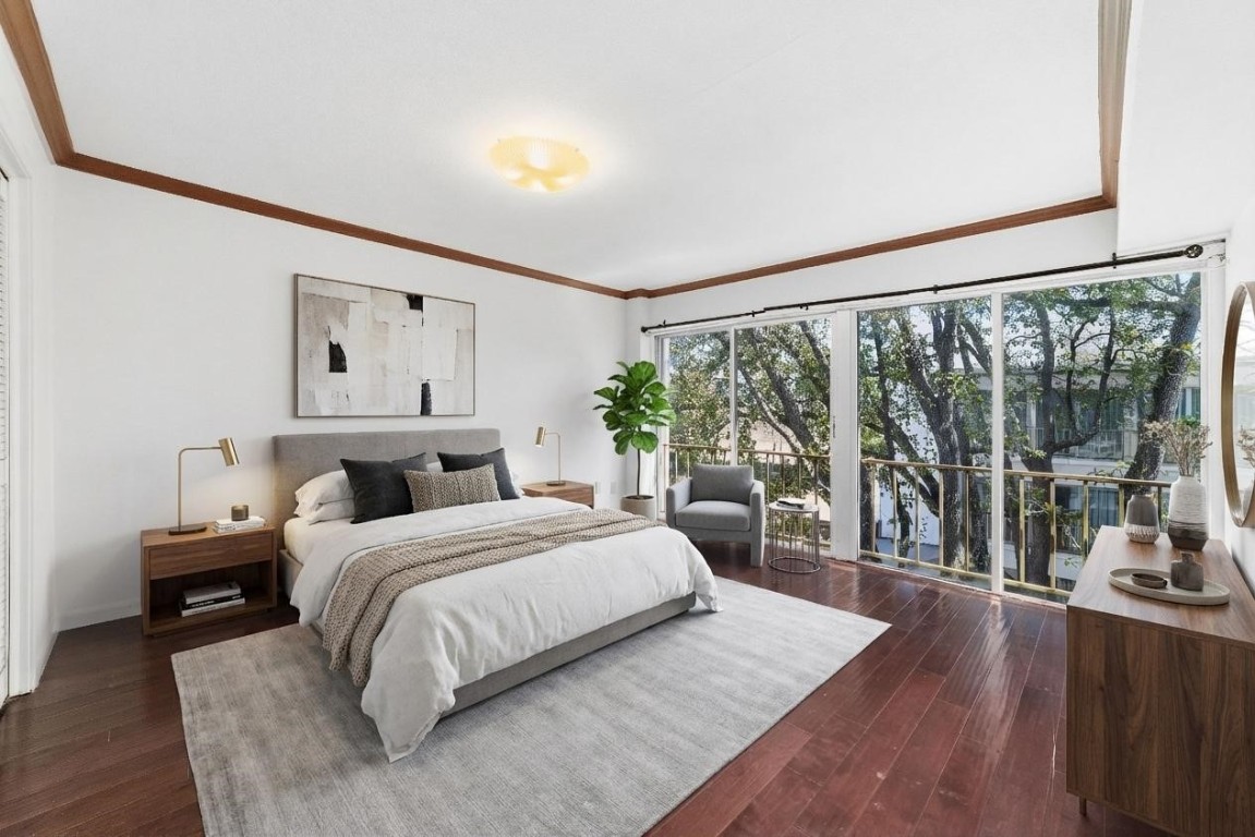 5050 Ambassador Way, Unit 309 Houston, TX 77056 - Photo 10 of 42 a bedroom with a large bed and a large window with wooden floor