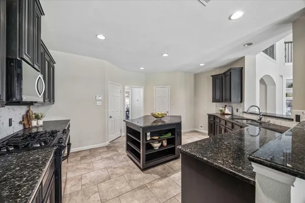 a spacious bathroom with a granite countertop sink a mirror a bathtub and shower