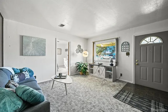a living room with furniture a window and a potted plant
