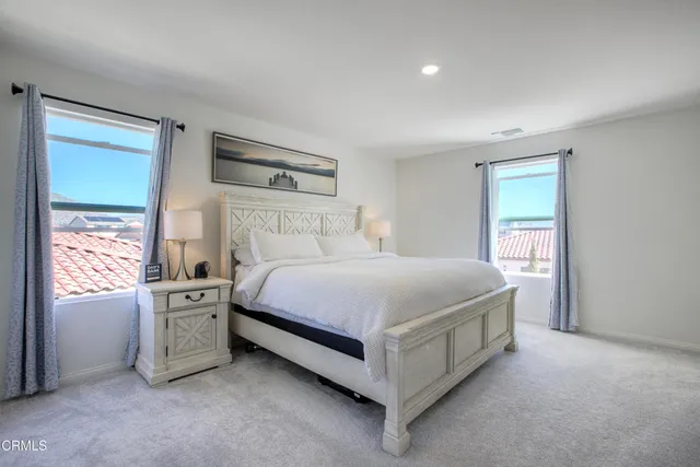 a spacious bedroom with a bed and a cabinets