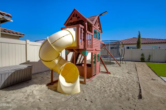 a view of a house with a small yard and a large tree