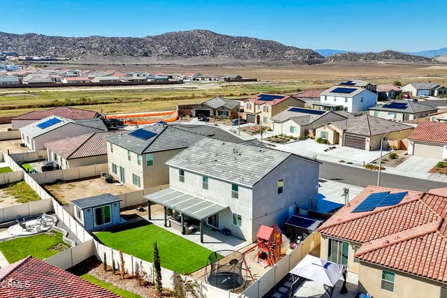 an aerial view of a house with a yard and furniture