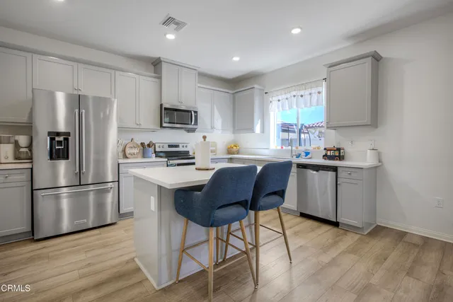 a kitchen with a refrigerator a microwave a sink and cabinets