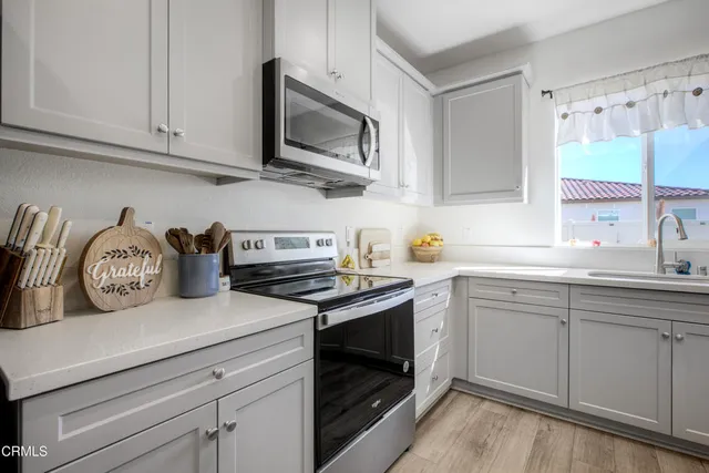 a kitchen with stainless steel appliances granite countertop white cabinets a sink and dishwasher