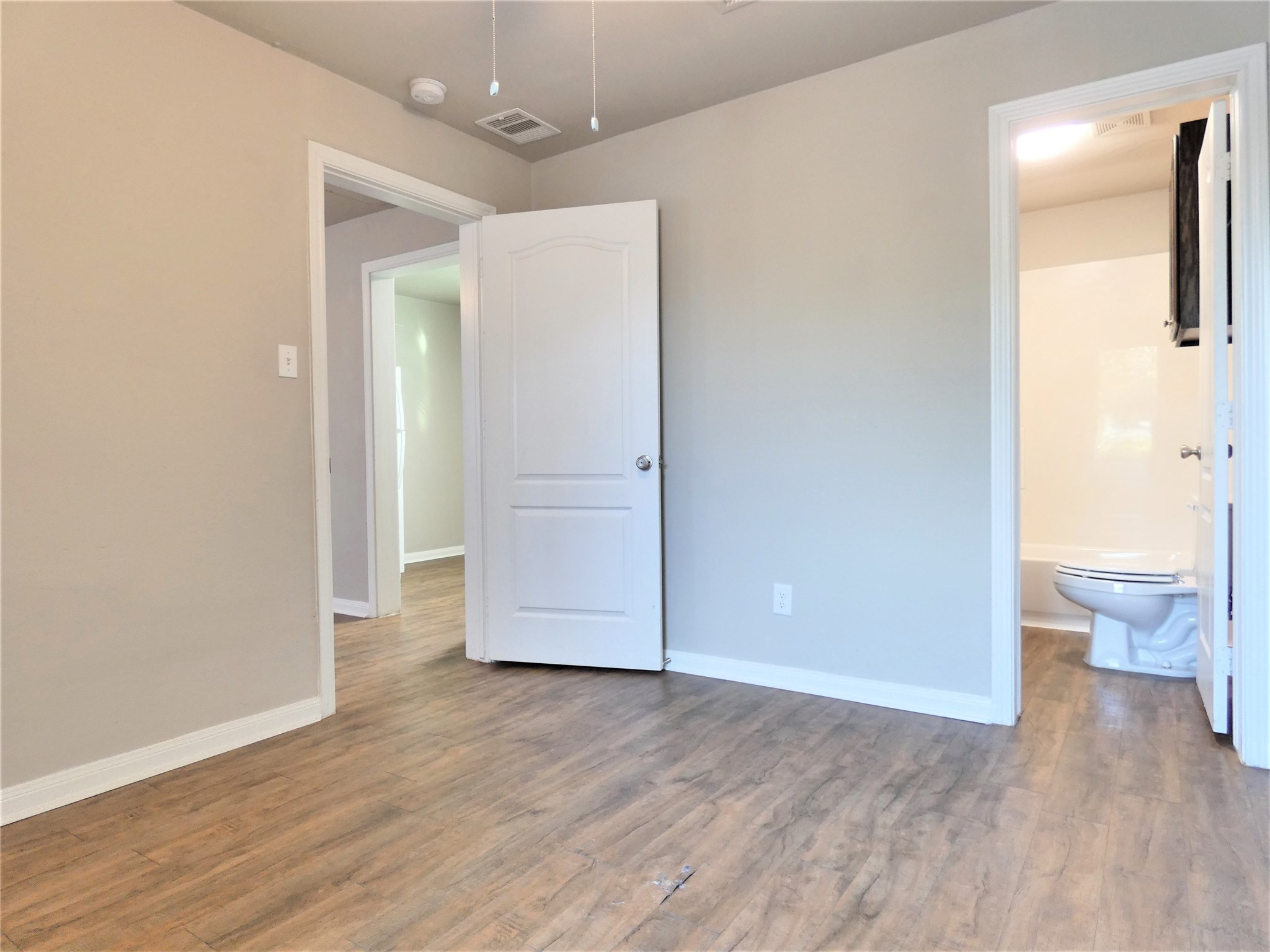 507 Houston Street, Unit 4 Rosenberg, TX 77471 - Photo 12 of 27 wooden floor in an empty room with a bathroom