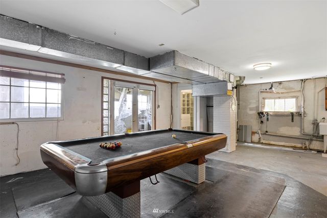 a room with pool table and windows