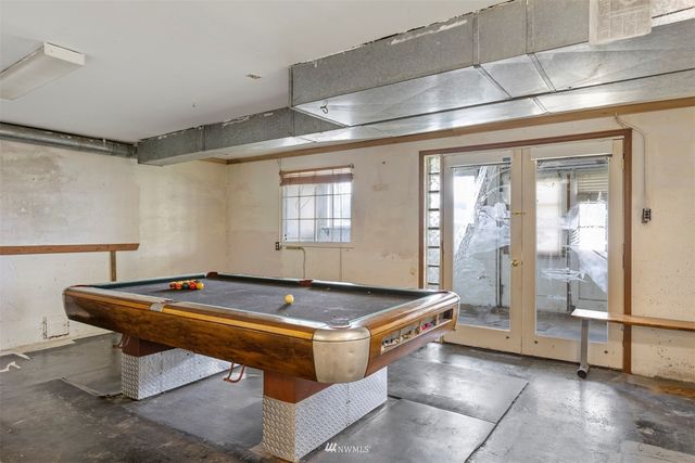 a room with pool table and windows