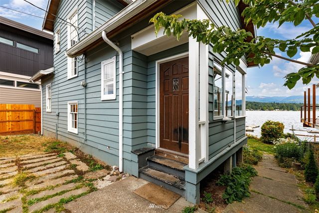 a view of a house with a door and a tree