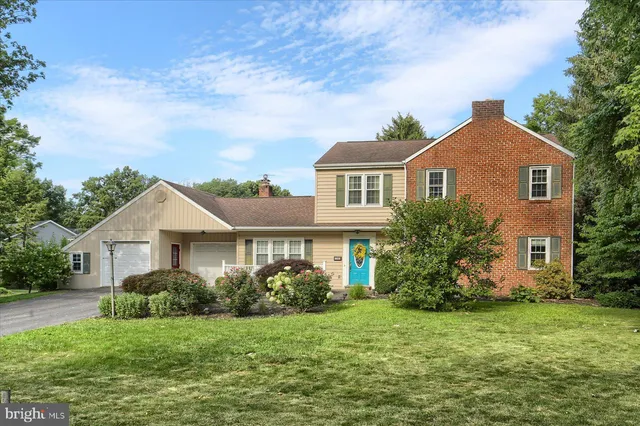 a front view of a house with a yard and trees