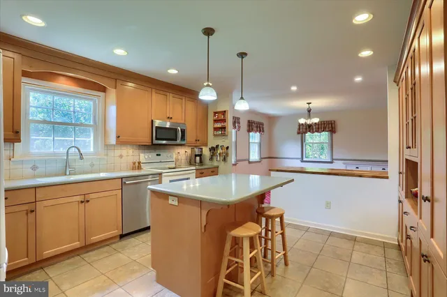 a kitchen with stainless steel appliances granite countertop sink stove top oven and cabinets