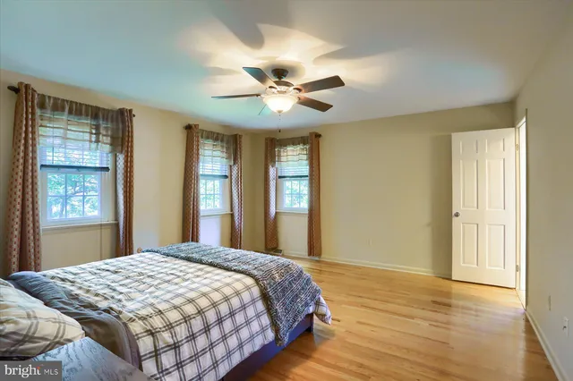 a bedroom with a large bed chandelier and a window