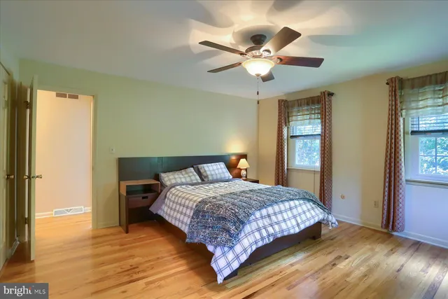 a bedroom with a large bed chandelier and a window