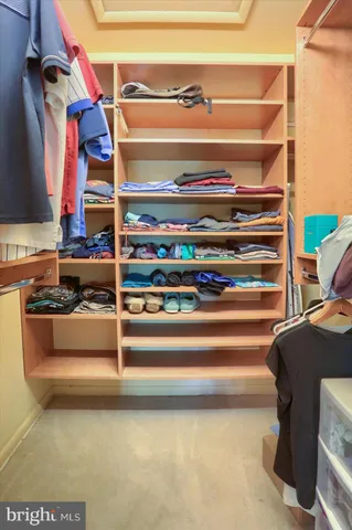 a view of walk in closet with clothes and shoes