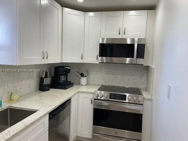 a kitchen with a sink and a stove top oven