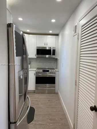 a kitchen with stainless steel appliances granite countertop a refrigerator and a stove top oven