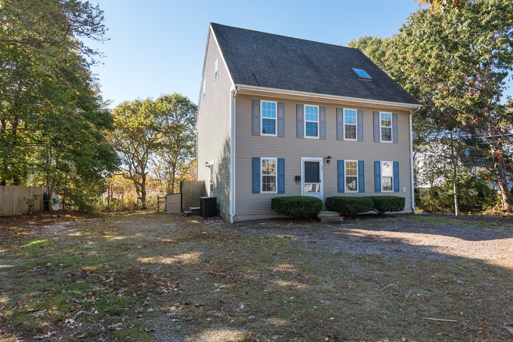 a view of a brick house with a big yard and large trees