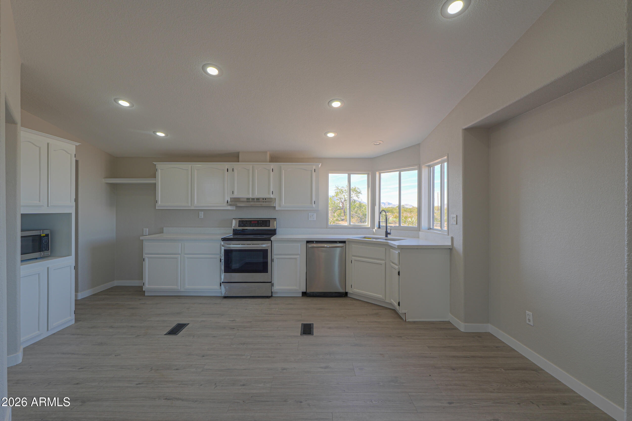 161 North Pueblo Road Maricopa, AZ 85139 - Photo 18 of 76 a kitchen with granite countertop white cabinets and stainless steel appliances