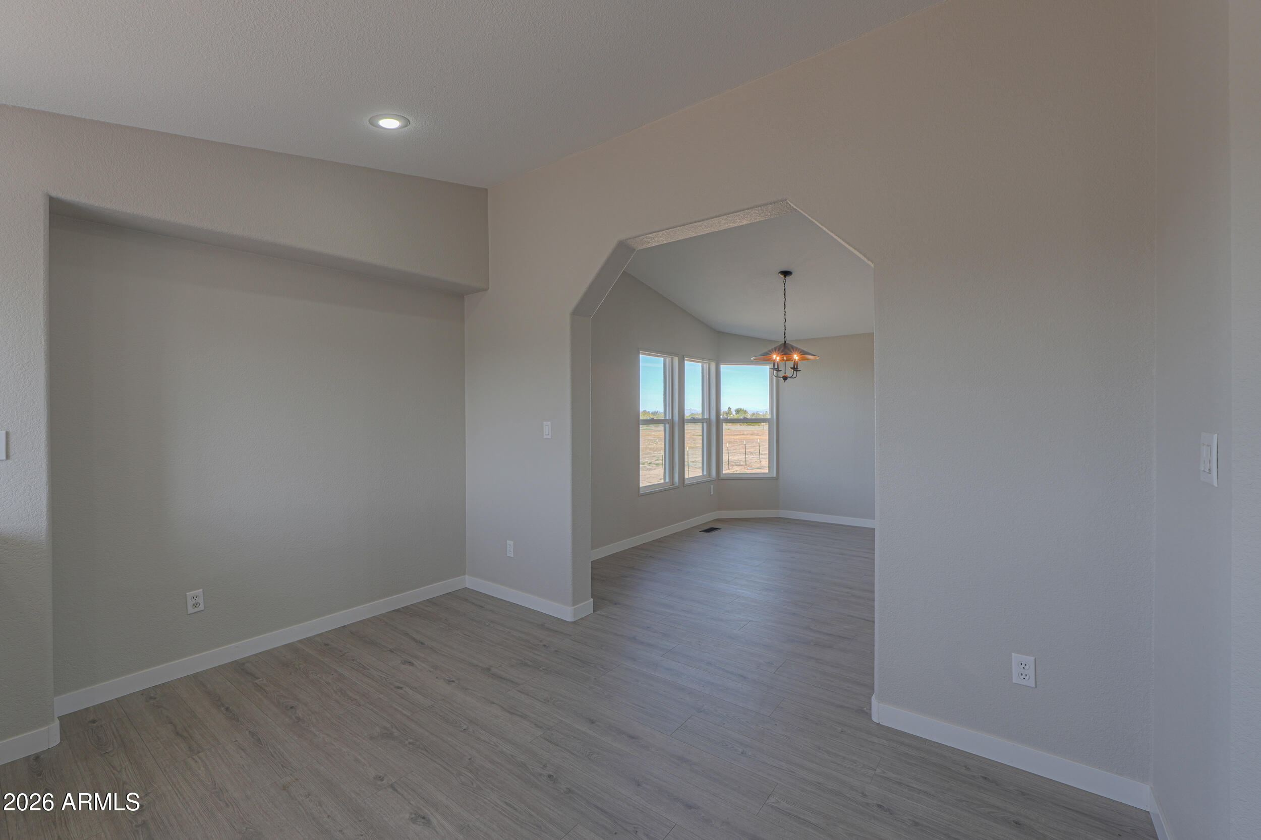 161 North Pueblo Road Maricopa, AZ 85139 - Photo 20 of 76 a view of an empty room with a window and wooden floor