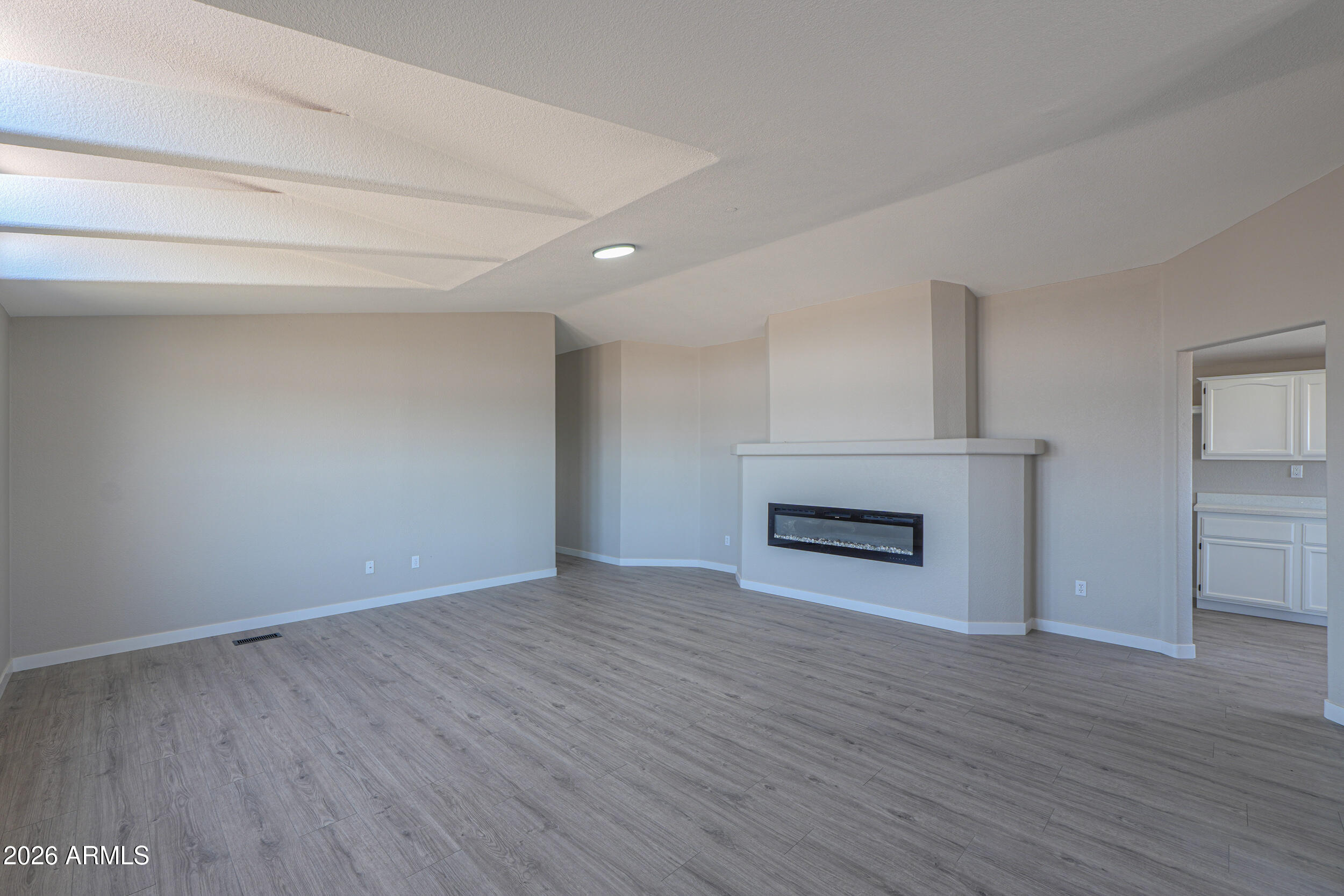 161 North Pueblo Road Maricopa, AZ 85139 - Photo 8 of 76 a view of an empty room with wooden floor fireplace and a window