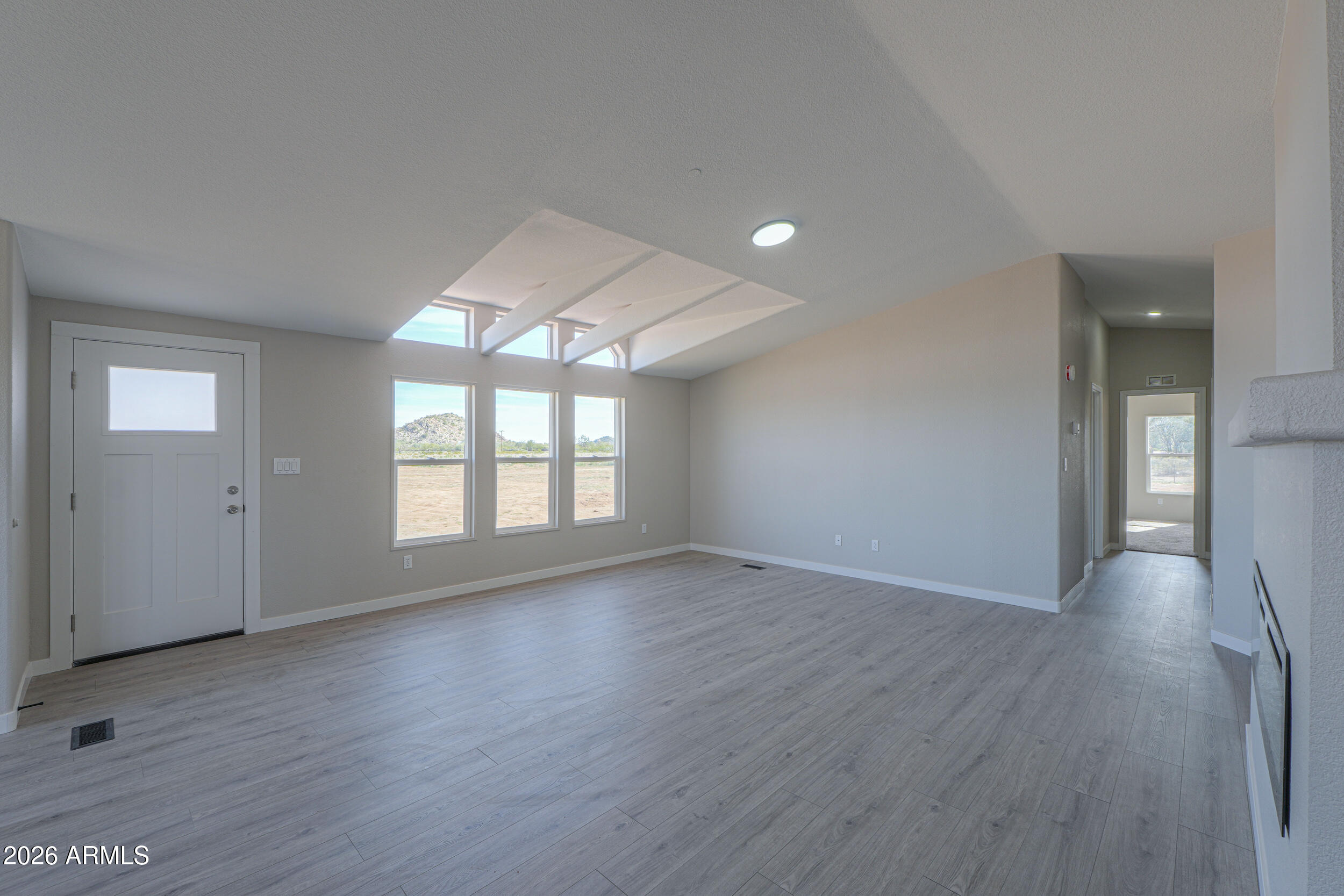 161 North Pueblo Road Maricopa, AZ 85139 - Photo 9 of 76 an empty room with wooden floor and windows