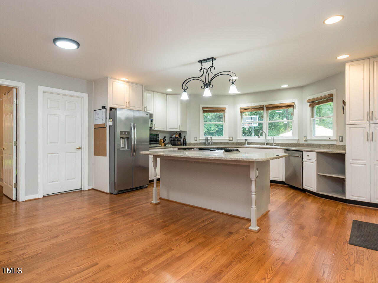 5912 Orchid Valley Road Raleigh, NC 27613 - Photo 5 of 62 a kitchen with stainless steel appliances kitchen island granite countertop a refrigerator a sink dishwasher a stove with wooden floors and cabinets