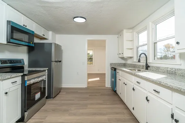 a kitchen with stainless steel appliances granite countertop a sink and a stove