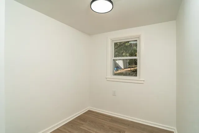 a view of a small space with wooden floor and a window