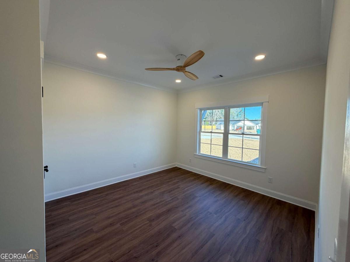 350 Rucker Lane, Unit AB Statesboro, GA 30458 - Photo 9 of 20 an empty room with wooden floor and windows