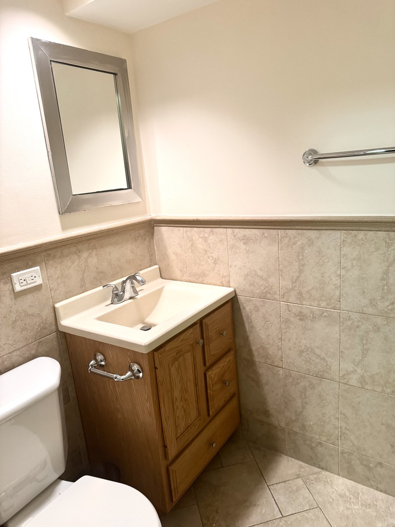 300 South Roselle Road, Unit 207 Schaumburg, IL 60193 - Photo 13 of 17 a bathroom with a sink a toilet and mirror