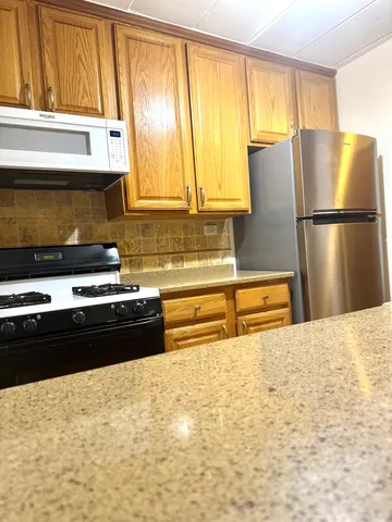 a kitchen with a stove a refrigerator and a window