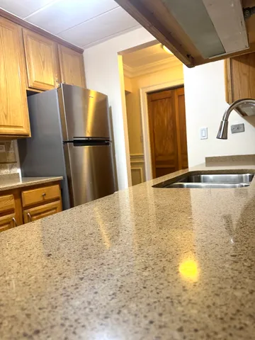 a kitchen with stainless steel appliances granite countertop a refrigerator a stove and a sink with granite countertops