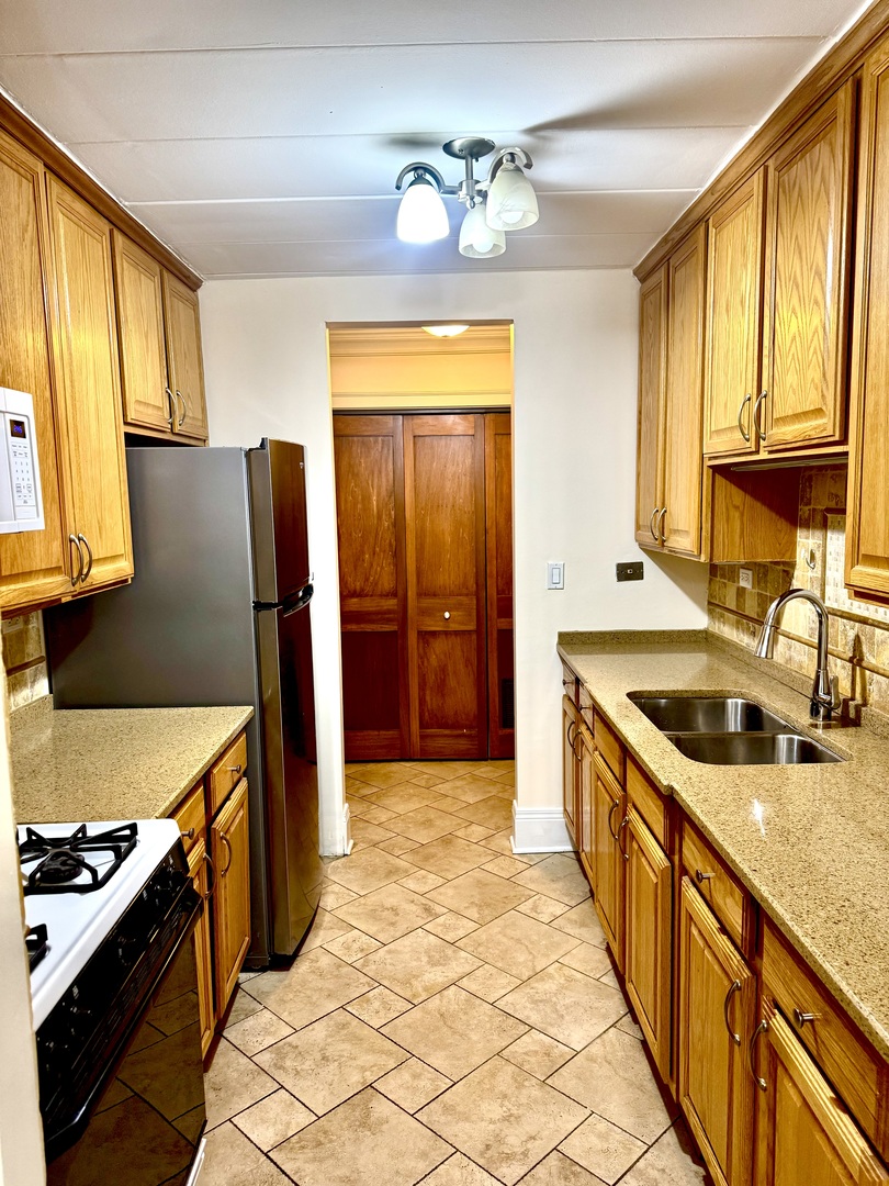 300 South Roselle Road, Unit 207 Schaumburg, IL 60193 - Photo 7 of 17 a kitchen with stainless steel appliances granite countertop a sink stove and refrigerator