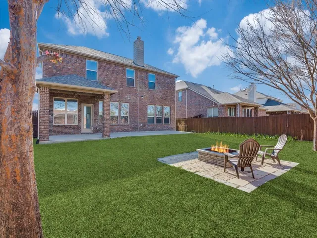 a view of an empty room with wooden floor fireplace and a window