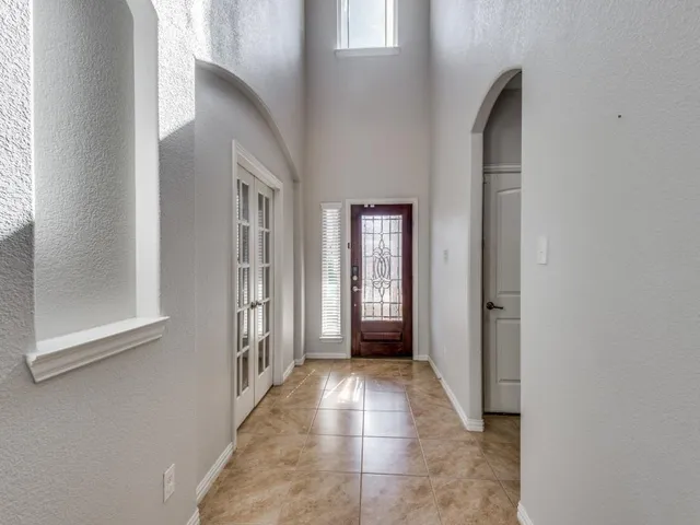 a view of an empty room with wooden floor and a fireplace
