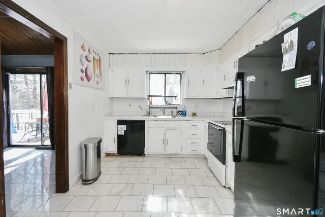 a kitchen with a sink a refrigerator and cabinets