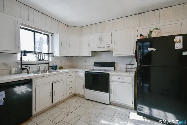 a kitchen with a refrigerator sink and cabinets