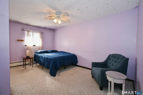 a bedroom with a bed a chandelier and a dresser