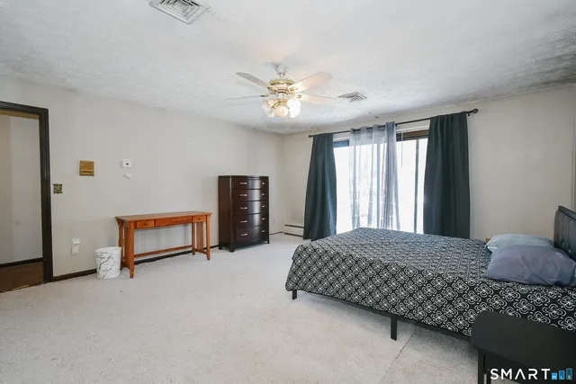 a bedroom with a bed and a ceiling fan