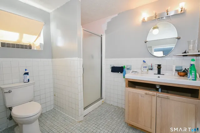 a bathroom with a toilet sink and mirror