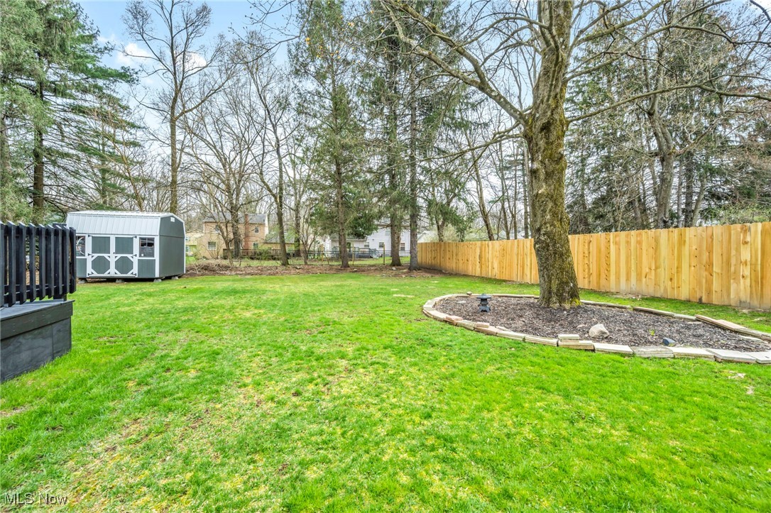 679 Garnette Road Akron, OH 44313 - Photo 36 of 47 View of yard with an outbuilding, a storage unit, and a fenced backyard