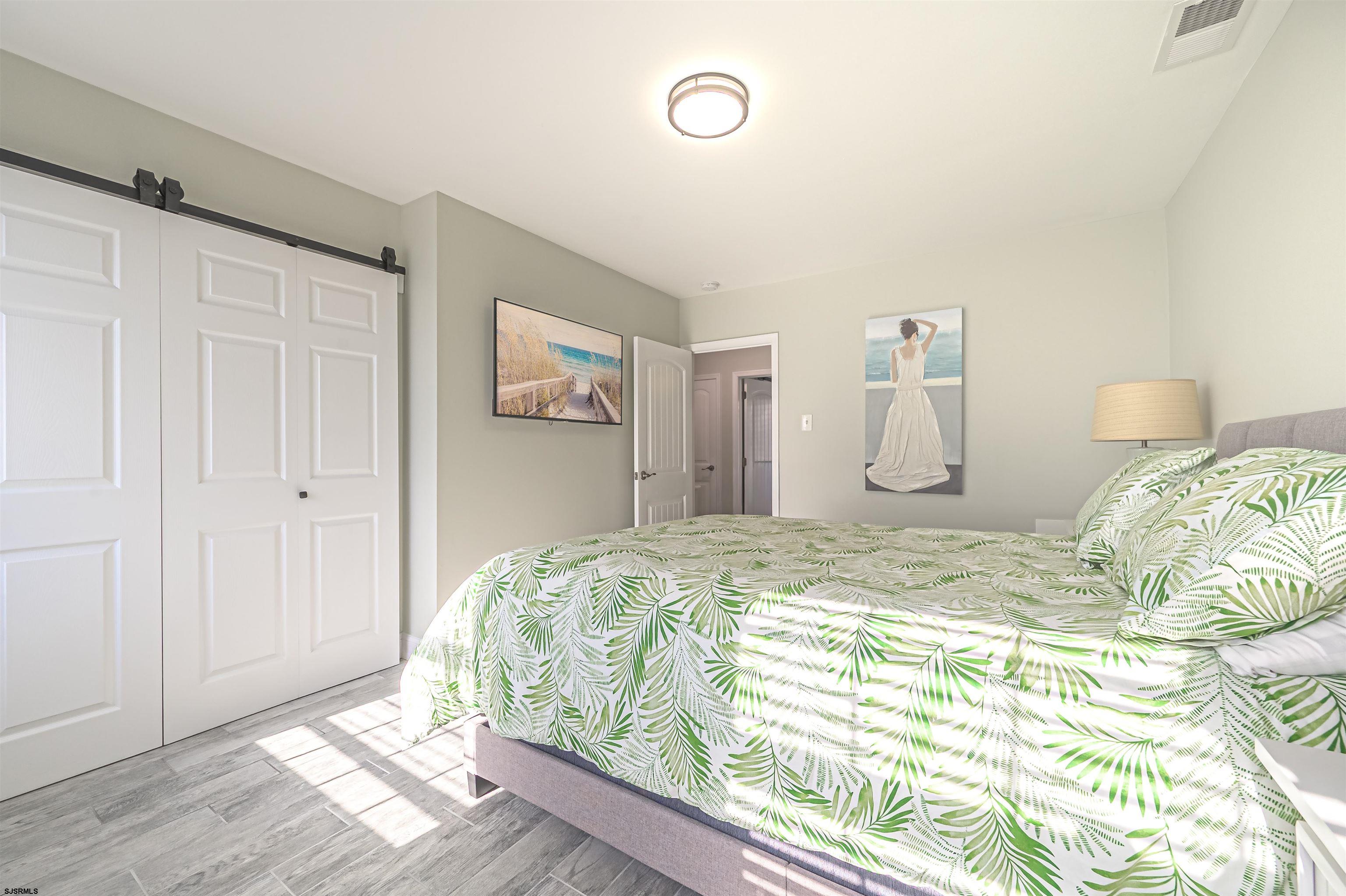 229 10th Street North, Unit 2 Brigantine, NJ 08203 - Photo 11 of 27 a bed sitting in a bedroom next to a cabinet