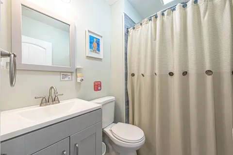 a bathroom with a sink a toilet and shower curtain