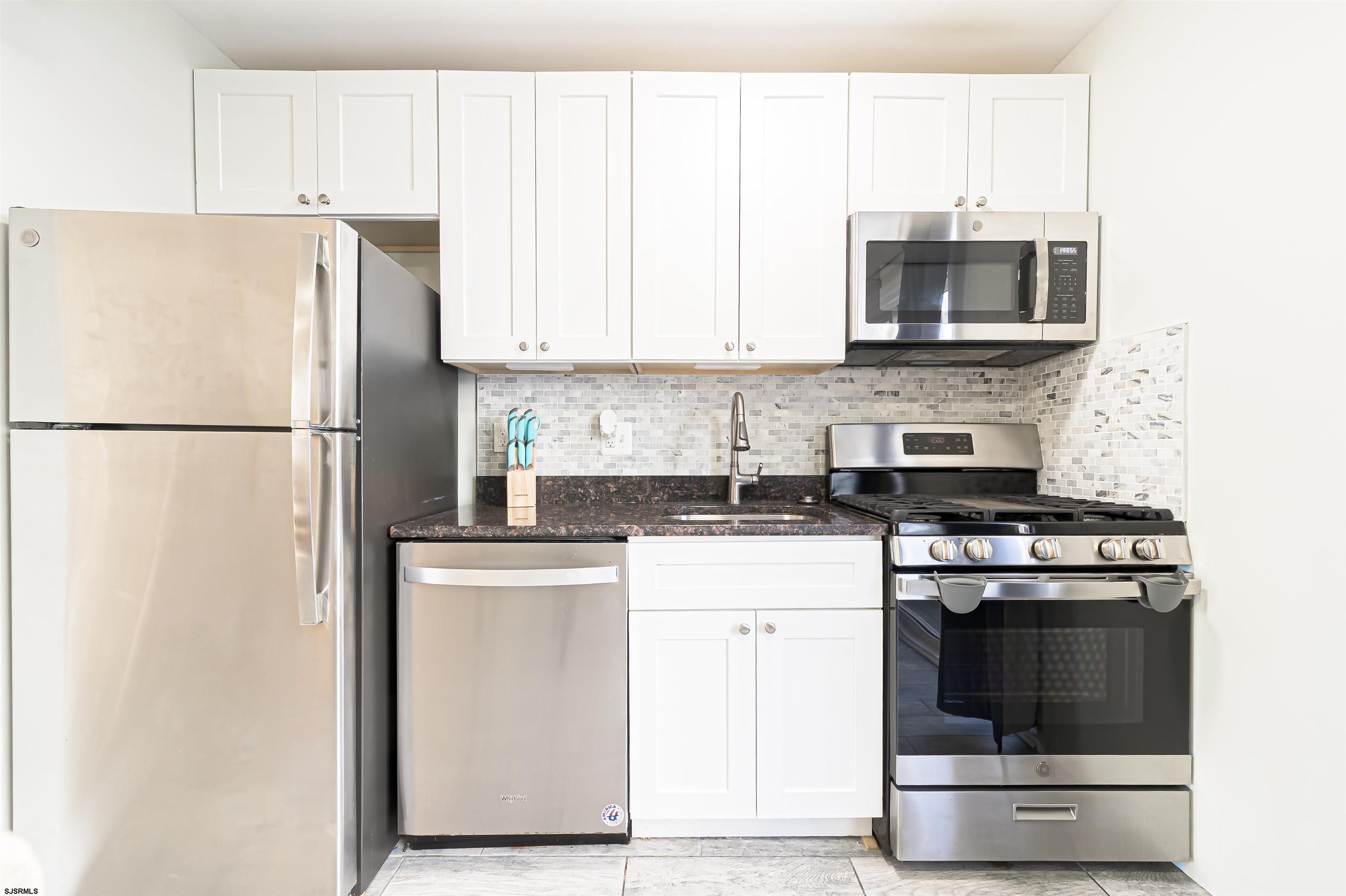 229 10th Street North, Unit 2 Brigantine, NJ 08203 - Photo 7 of 27 a kitchen with a stove a sink and a refrigerator