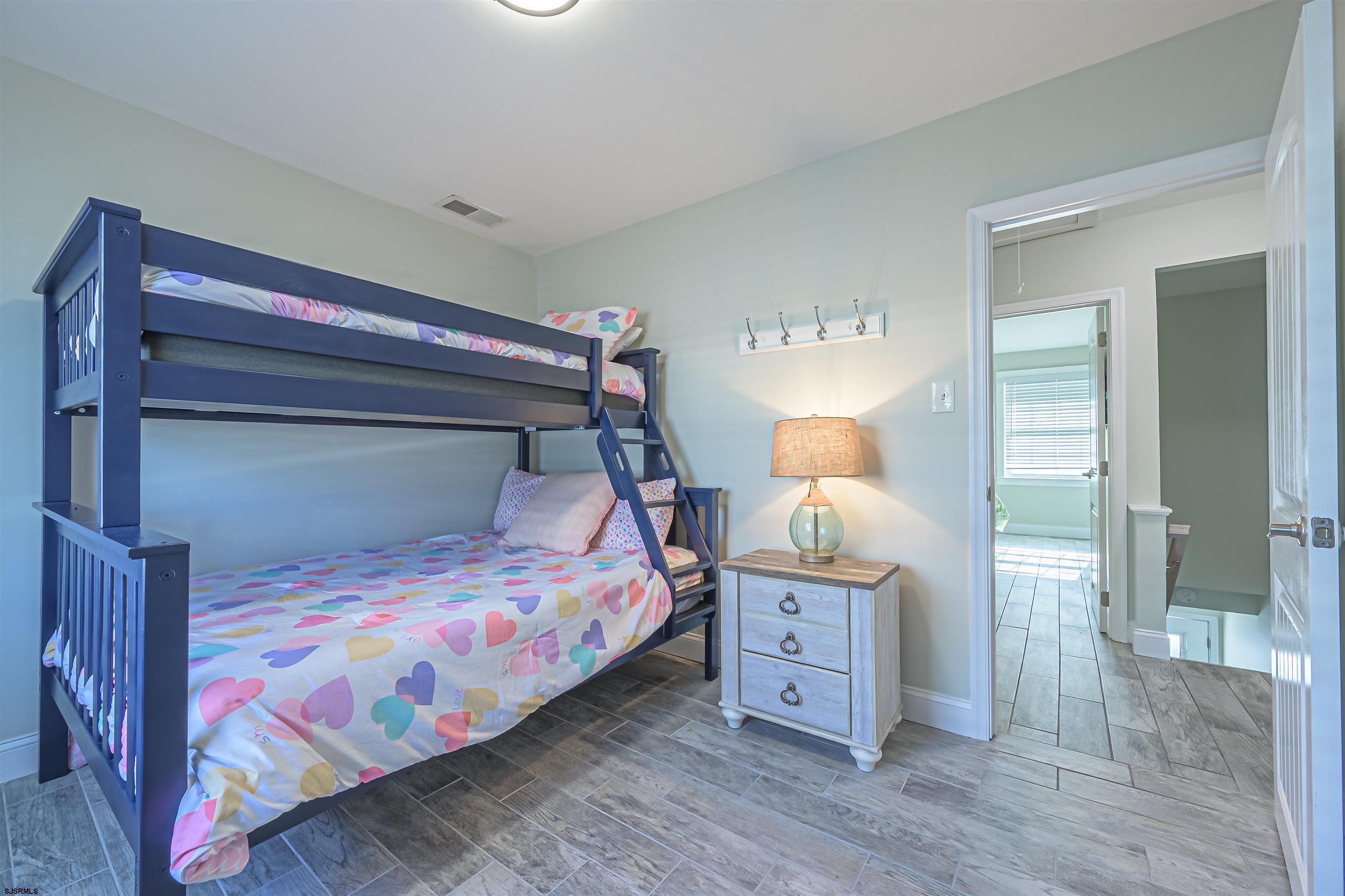 229 10th Street North, Unit 2 Brigantine, NJ 08203 - Photo 9 of 27 a bedroom with a bed and wooden floor