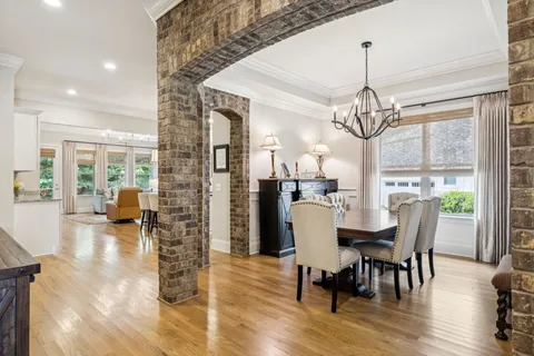 a view of a dining room with furniture a chandelier and wooden floor
