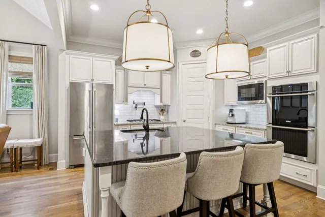 a kitchen with stainless steel appliances granite countertop a sink a stove and a wooden floors