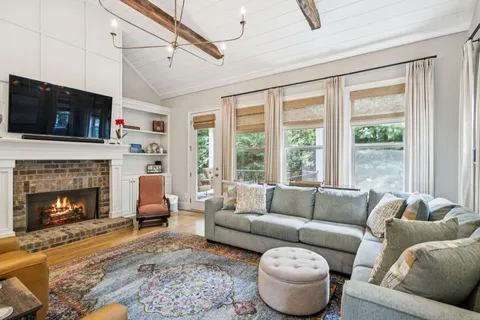 a bedroom with a bed couch chandelier and a window