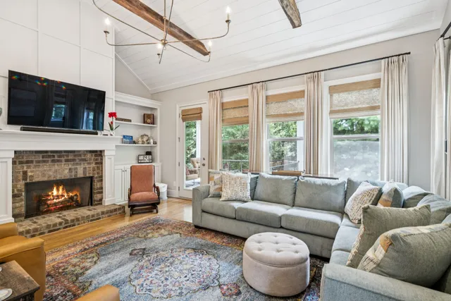 a bedroom with a bed couch chandelier and a window
