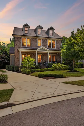 a porch with chairs and potted plants
