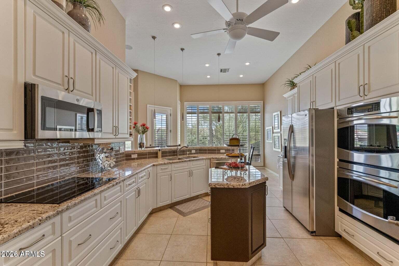 26601 North Aguila Road Rio Verde, AZ 85263 - Photo 13 of 45 a large kitchen with kitchen island a sink stainless steel appliances and cabinets
